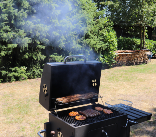 Rokende barbecue in de tuin met veel vlees erop