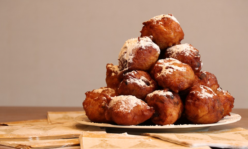 Oliebollen met poedersuiker op een bordje