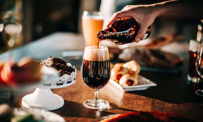 Donker bier inschenken op een feestelijke tafel