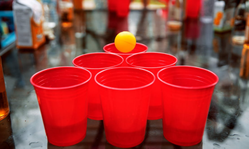 Beerpong met rode cups en oranje balletje