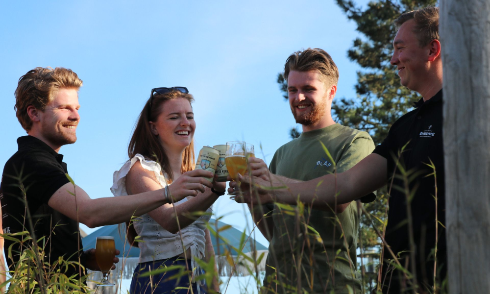 Vier mensen proosten met bier van Brouwerij de Herenweg