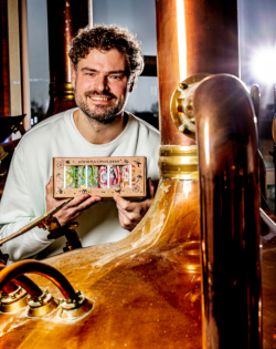 Vrolijke man met Maximus bierpakket bij de brouwketel