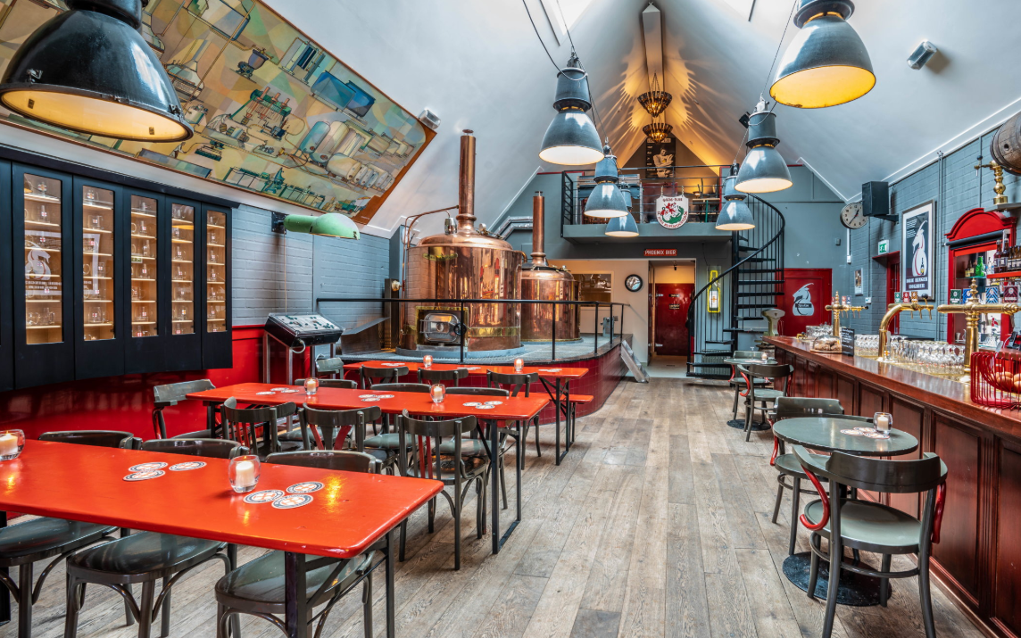 Tafels stoelen en op de achtergrond de brouwketel bij stadsbrouwerij de drie ringen in amersfoort