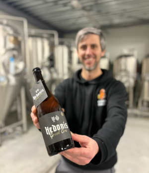 Brouwer houdt trots het Hedonis Grand Cru jubileumbier vast