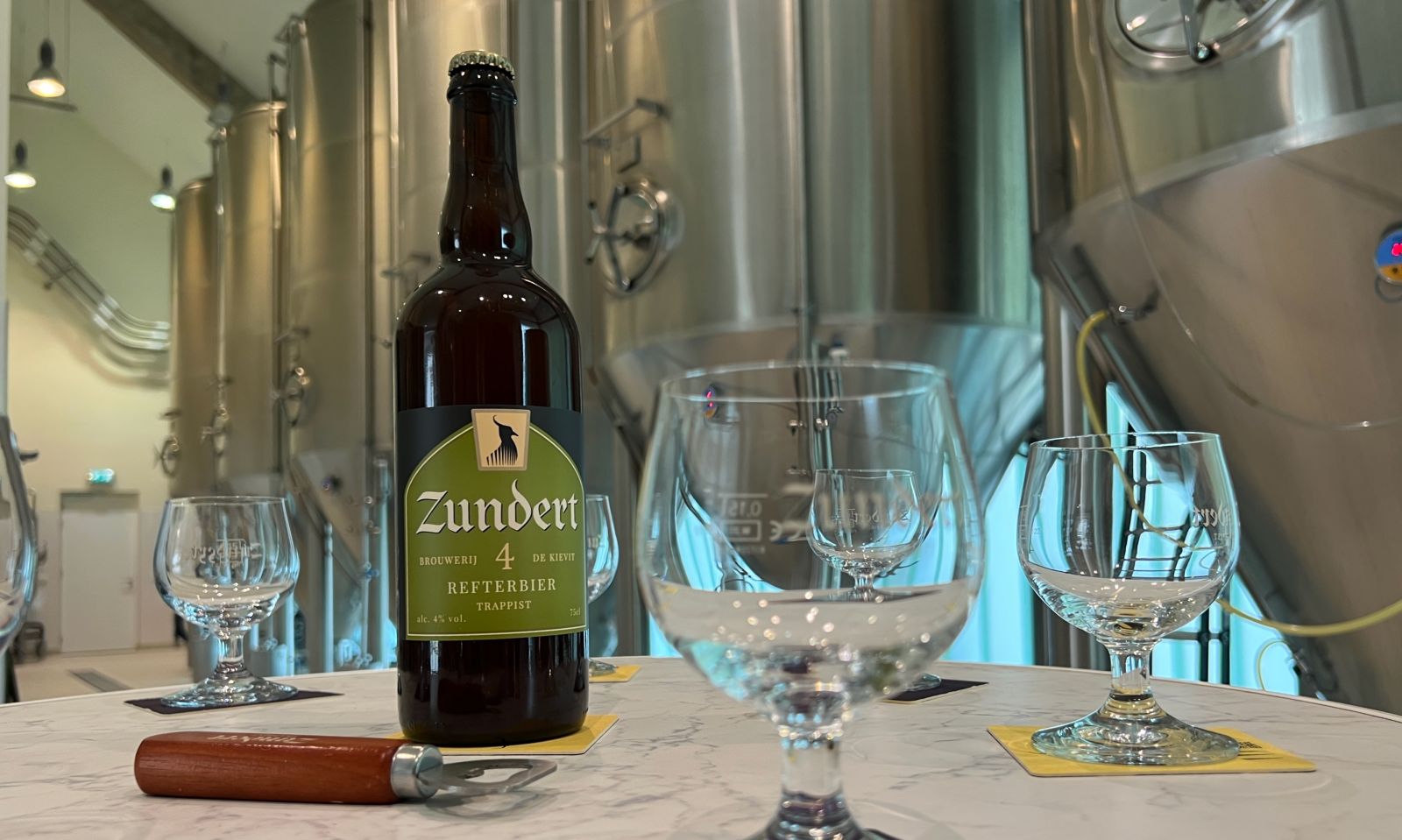 Zundert 4 Refterbier grote 75cl fles naast glazen in de brouwerij
