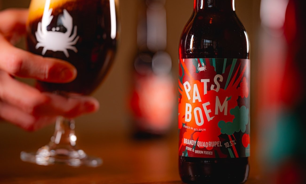 Eerste Patsboem bier van Scheldebrouwerij flesje en glas op de achtergrond