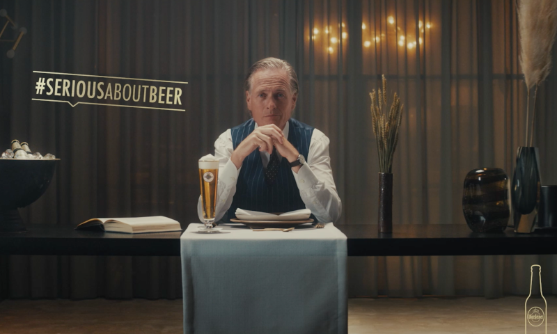 Jort Kelder achter een tafeltje met een glas Warsteiner voor zich