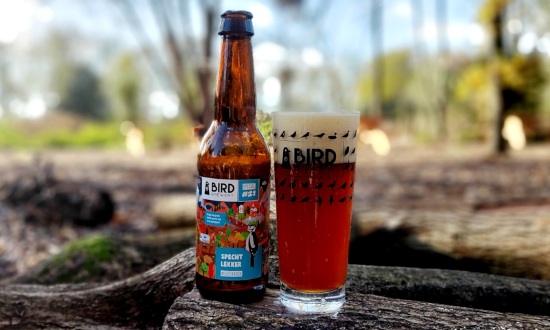 Specht Lekker Weizenbock van Bird Brewery op een boomstam in het bos