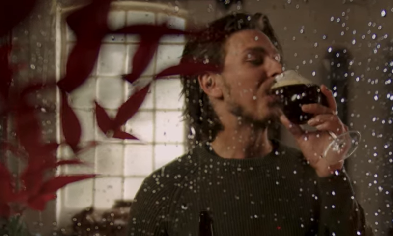 Man geniet binnen van DAVO Weizenbock terwijl het buiten herfstig is