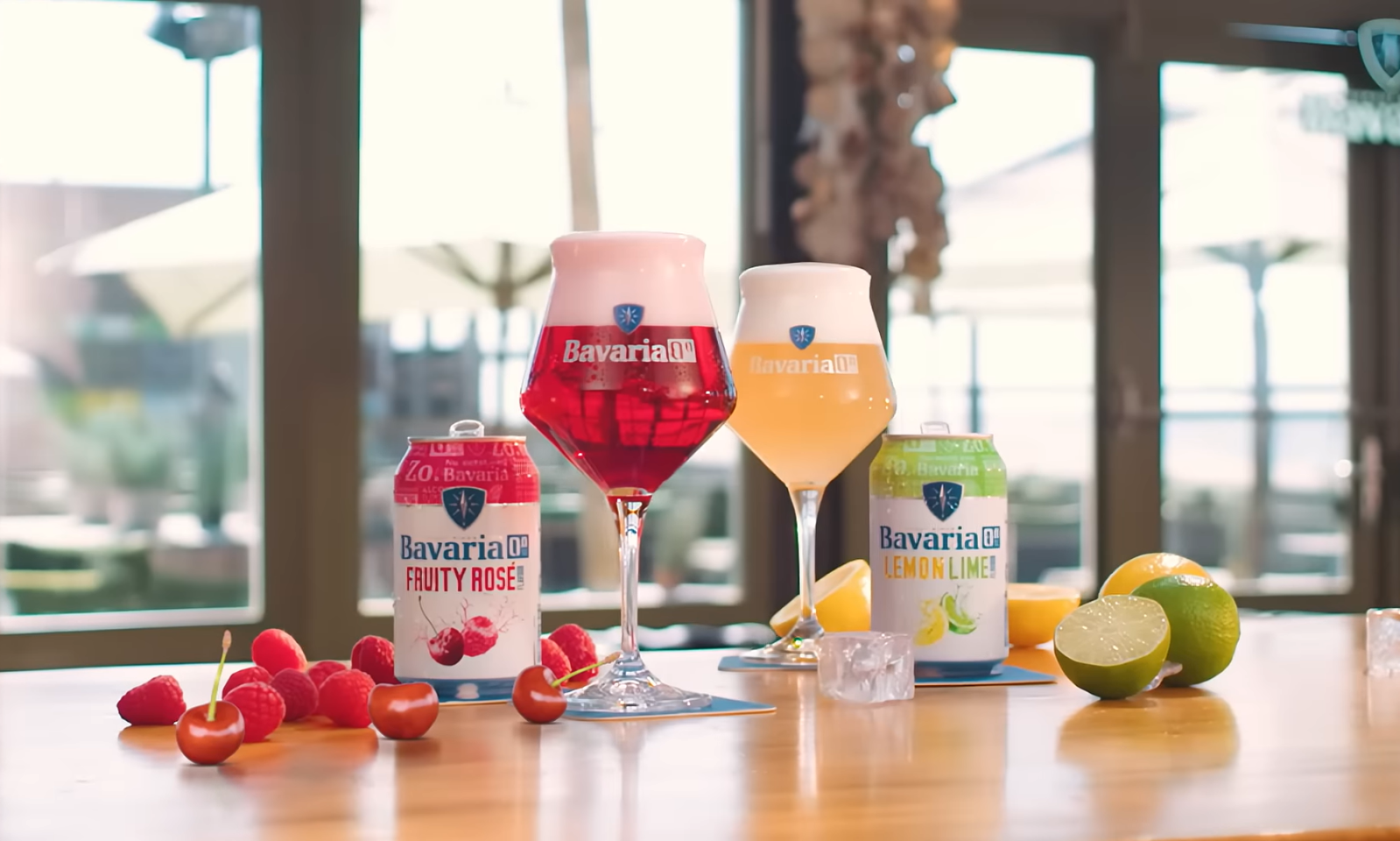 Blikjes Bavaria Fruity Rosé en Lemon Lime op tafel met glazen en vers fruit.