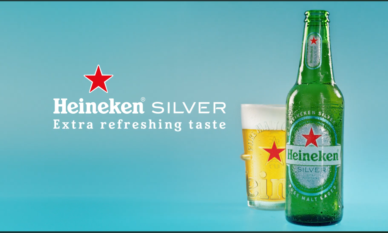 Heineken Silver fles en glas bier op een blauwe achtergrond.