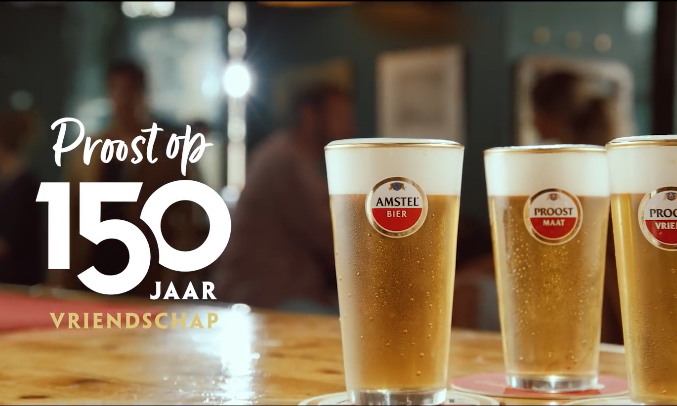 Drie Amstel bierglazen op een bar met tekst 