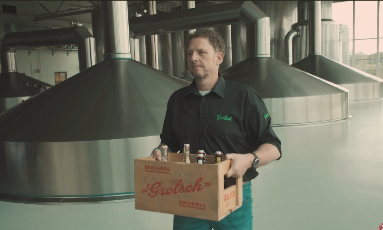 Meesterbrouwer houdt een houten krat met Grolsch bier in een brouwerij.