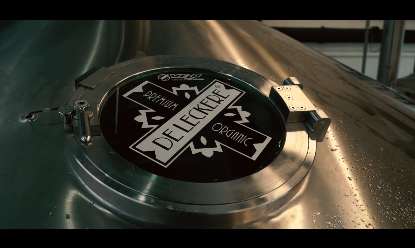 Zilverkleurige bierbrouwtank met De Leckere logo in een brouwerij.