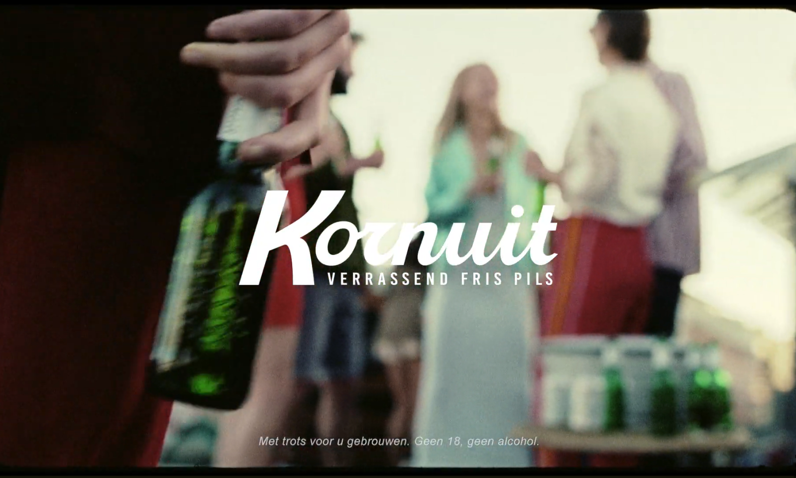 Mensen op een buitenfeestje met Kornuit bier in de hand.