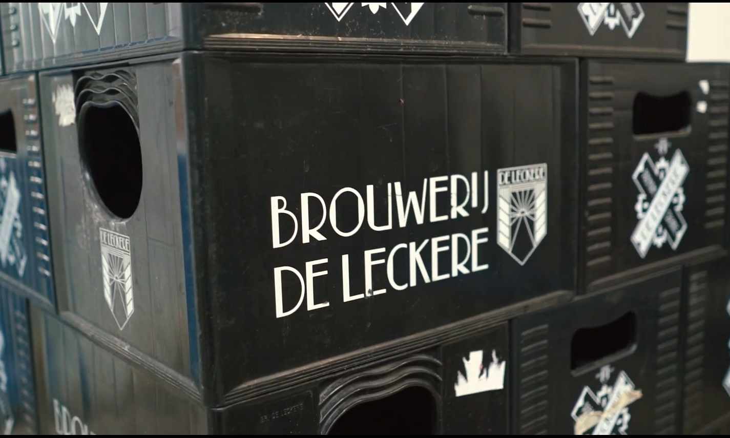 Zwarte kratten met tekst Brouwerij De Leckere en logo in een opslagloods.