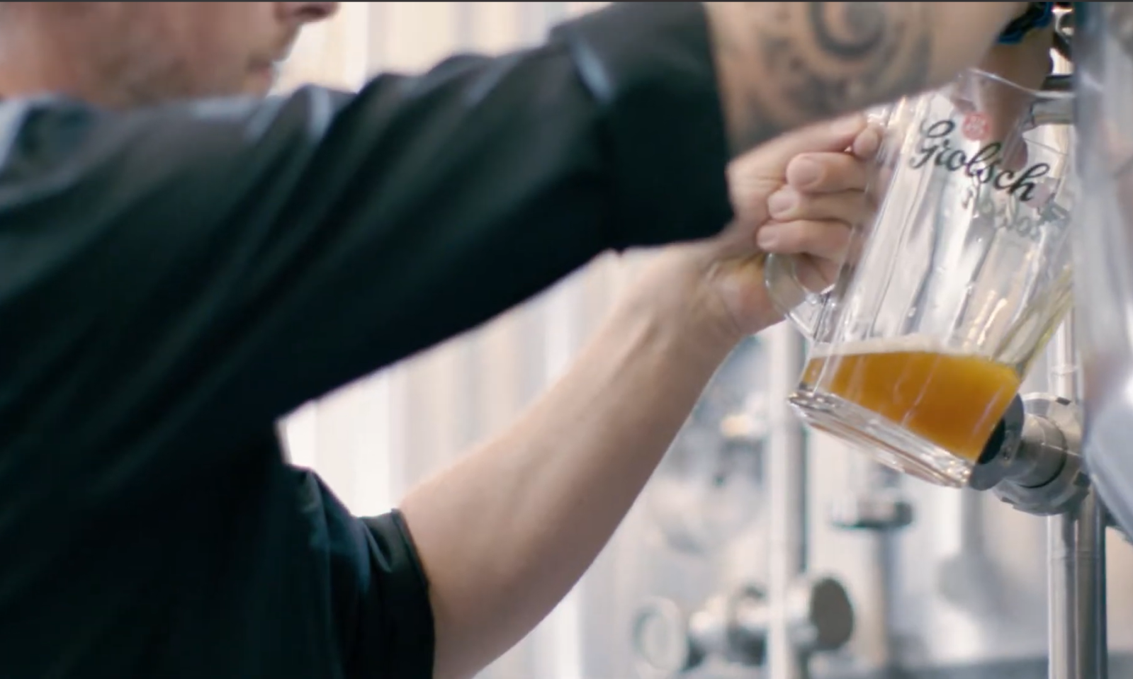 Close-up van een hand die een glas vult met bier uit een biertap.