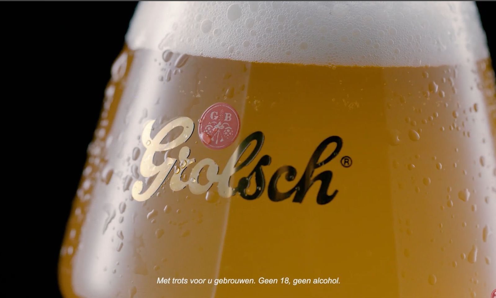 Close-up van een glas Grolsch bier met logo en condensdruppels