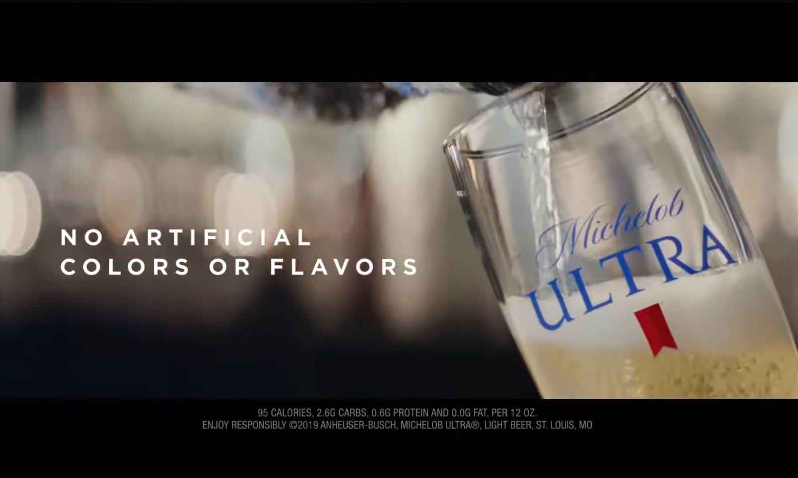 Een glas Michelob ULTRA bier wordt ingeschonken met de tekst 'No artificial colors or flavors'.