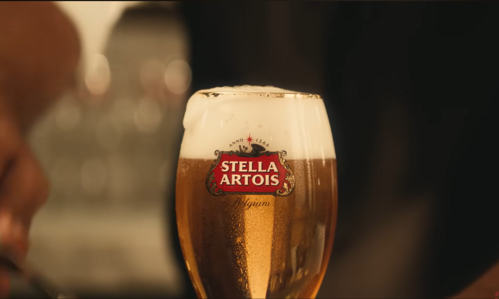 Close-up van een glas Stella Artois bier met schuimkraag en branding.
