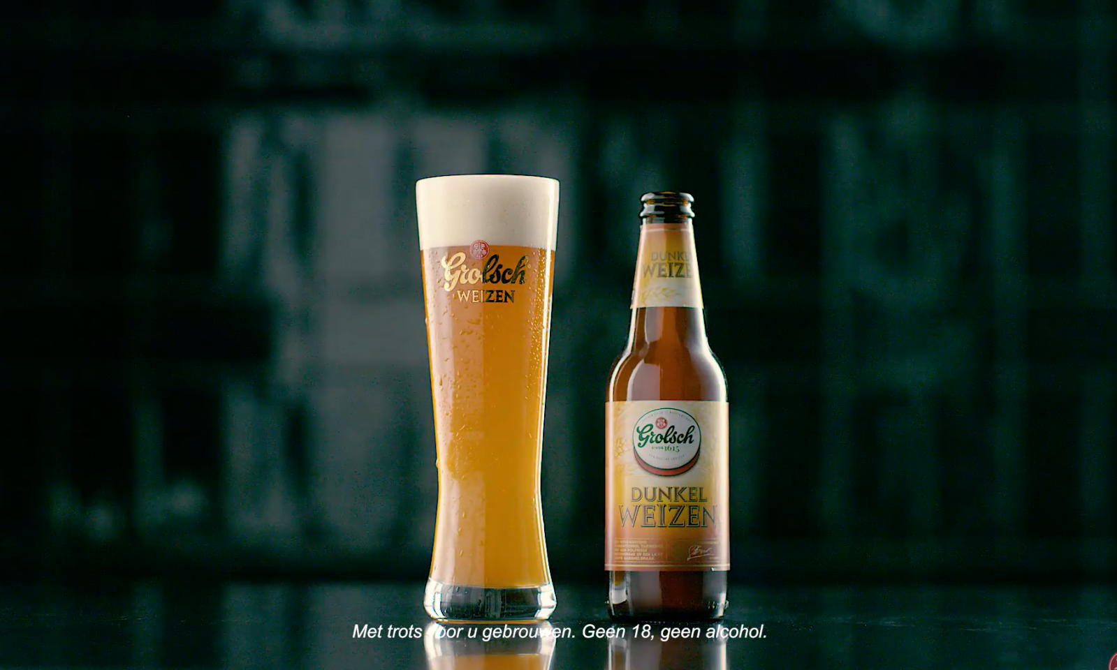 Glas en fles Grolsch Dunkel Weizen met tekst op donkere achtergrond.
