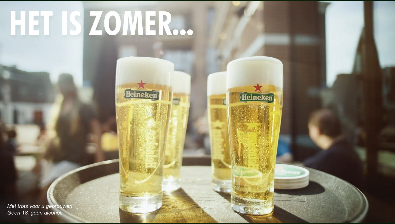 Vier glazen Heineken-bier op een tafel, zomerse sfeer.