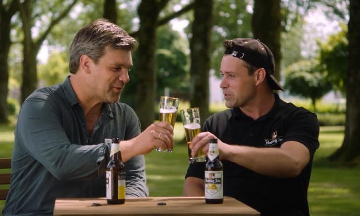 Rij flessen Hertog Jan Bastaard bier op een lopende band in een brouwerij.