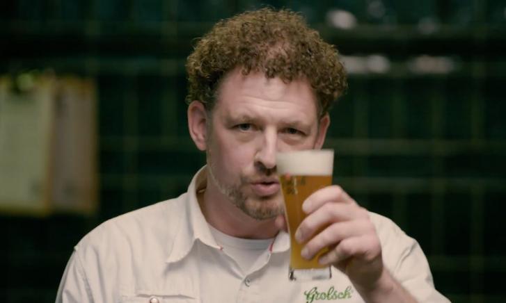 Glas en fles Grolsch Weizen IPA op een donkere achtergrond.