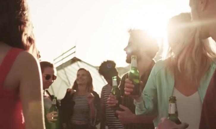 Groep mensen buiten met Kornuit bier in de hand.