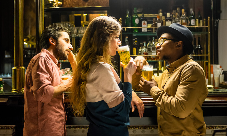 Groene Grolsch bierfles voor gestreepte achtergrond