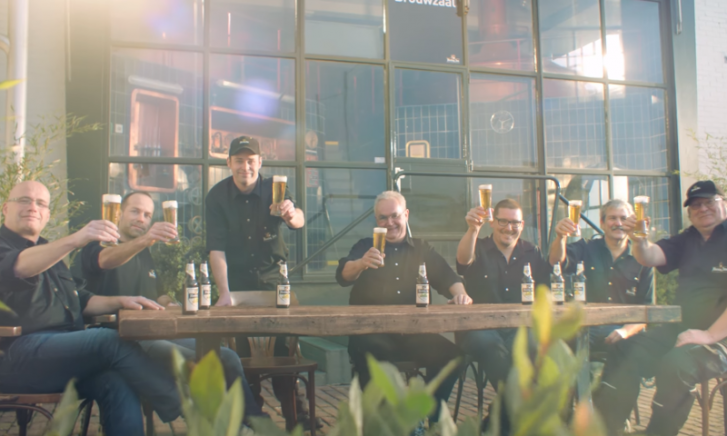 Close-up van een glas Hertog Jan Bastaard bier op een bar met onscherpe achtergrond.
