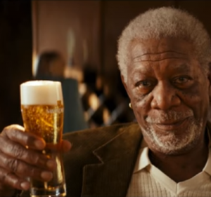 Man zittend in een chique hotel lounge met een fles en glas op tafel.