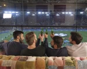 Groene helikopter op groot scherm in stadion met tekst onderaan.
