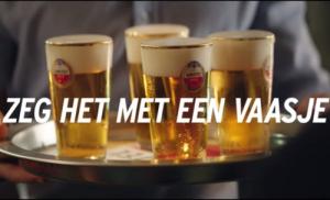 Close-up van een biertje dat wordt getapt in een glas met Amstel-logo.