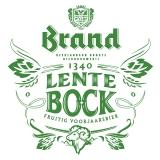 Glas Brand bier naast bloeiende witte bloemen in de lente.