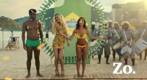 Twee vrouwen in zomerkleding met Bavaria flesjes op een zonnig strand.