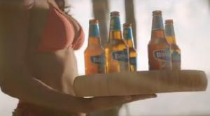 Bavaria Radler flessen en glazen met citrusvruchten op een tafel aan zee.