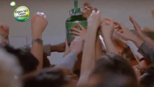 Twee Heineken vaatjes in een koelkast met een persoon op de achtergrond.