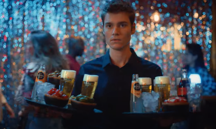 Barman met twee dienbladen met drankjes en bier