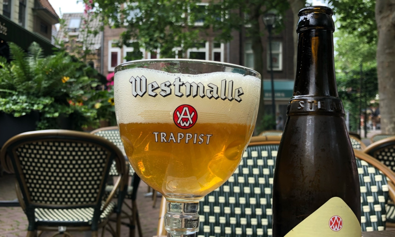 Westmalle Trappist Tripel flesje en glas op een terras