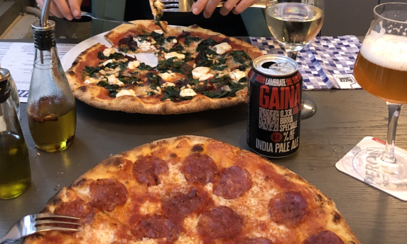 Twee pizza's met een glas bier erbij